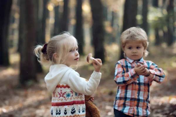 Garçon et fille sur le chemin forestier pour les champignons. Les enfants tiennent le champignon à la main — Photo