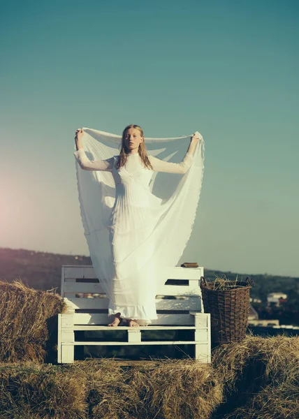 Женщина невеста в свадебном платье на деревянной скамейке. Чувственная женщина с длинными светлыми волосами. Девочка-альбинос на фоне пейзажа, природной красоты. Модель моды на солнечном голубом небе — стоковое фото