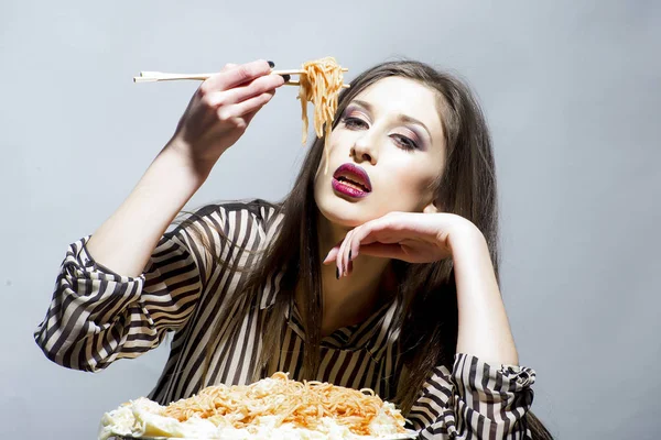 女の子は、トマト ケチャップを使ったパスタ料理を食べる。女の子は、イタリア料理の食事を持っています。 — ストック写真