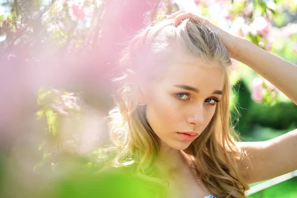 Concept de fleur de printemps. Dame dans le parc le jour du printemps. Fille sur le visage rêveur, blonde tendre près de fleurs violettes de Judas arbre, fond nature. Les jeunes femmes aiment les fleurs dans le jardin, déconcentré, gros plan . — Photo