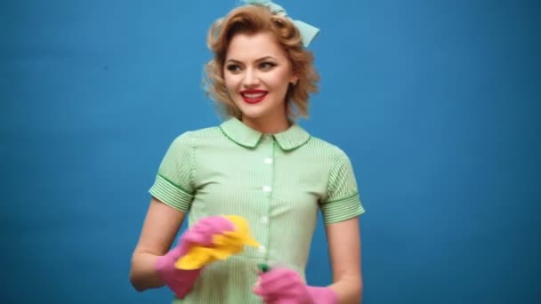 Pin up woman in gloves smiling and wiping dust using a spray and a duster. Cleaning concept with supplies. Beautiful young woman makes cleaning. Pin up cleaning. Beautiful woman in gloves cleaning. — Stock Video