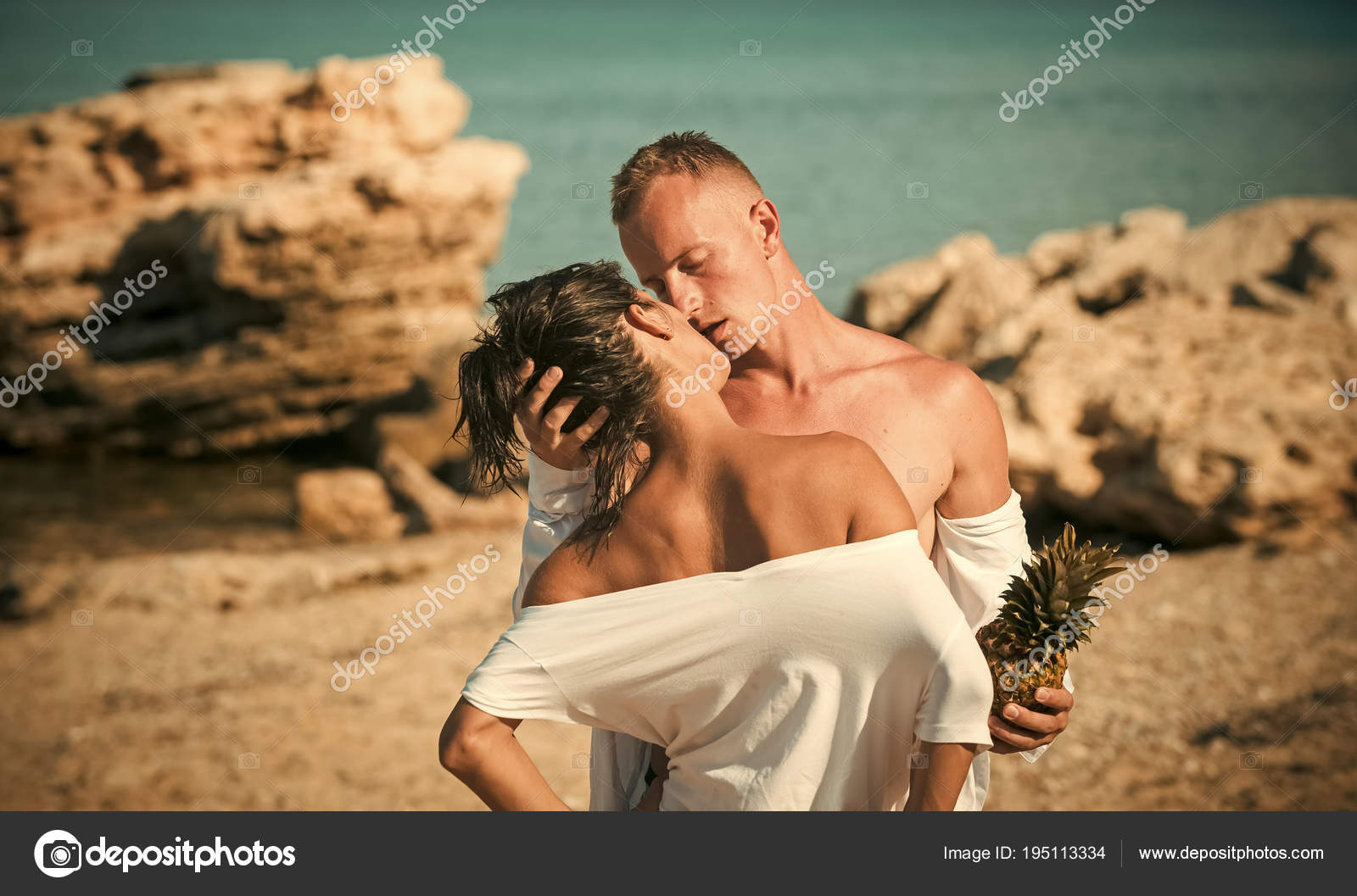 Beach Couple Kissing Naked - Passionate couple on vacation hold pineapple. Couple stand ...