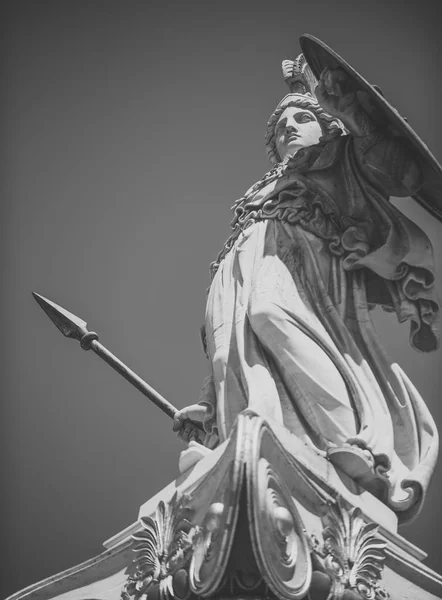 Statue, sculpture of Greek warrior in helmet with spear and shield. White sculpture ancient greek god of war with gilding. Statue of man in armor with blue sky on background — Stock Photo, Image