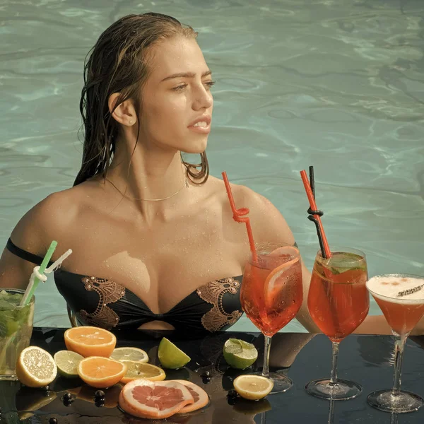 Γυναίκα στην πισίνα με κοκτέιλ και φρούτα σε καλοκαιρινές διακοπές — Φωτογραφία Αρχείου