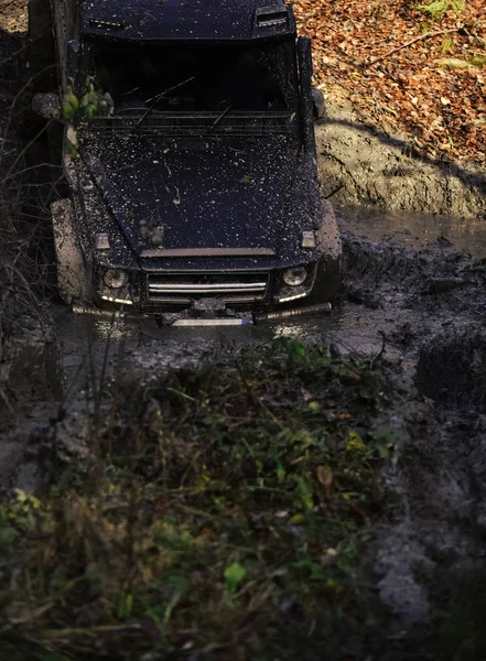 Μαύρο crossover οδήγηση μέσα από χώμα με τη φύση σε φόντο. — Φωτογραφία Αρχείου