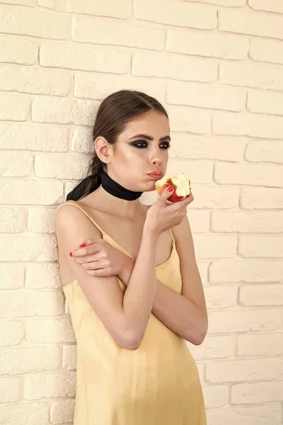 Kvinnan håller frukt med sotade ögon ansikte makeup — Stockfoto