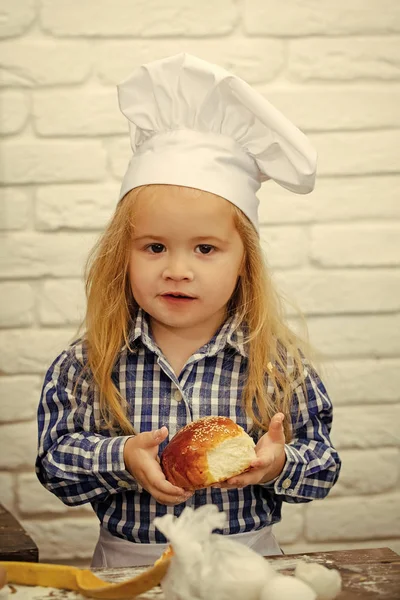 Boy cook in chef hat in kitchen