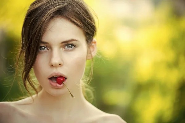 口の中で桜のベリーを持つ少女 — ストック写真