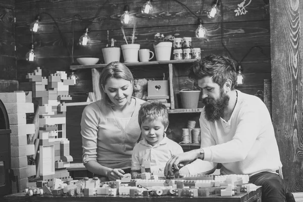 Familia feliz jugando con el constructor en casa. madre y padre ayudando a construir con ladrillos —  Fotos de Stock
