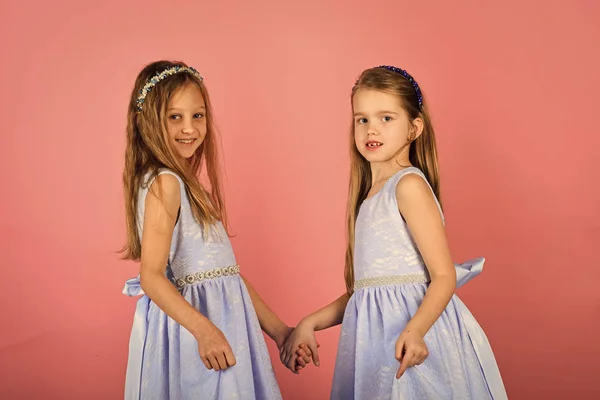 Trzy małe dziewczynki Ładna sukienka na różowym tle. — Zdjęcie stockowe