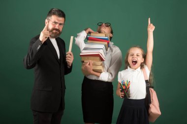 Okulda kitap okumak. iki kız öğrenciler ve öğretmen ile ders okuma.