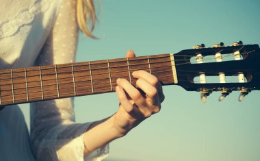 Akustik gitar açık oynayan genç kadının el closeup