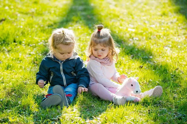 Soeur et frère s'assoient sur l'herbe verte — Photo