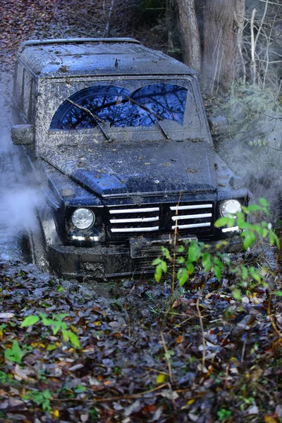 Car moving through a large puddle of mud — Stock Photo, Image