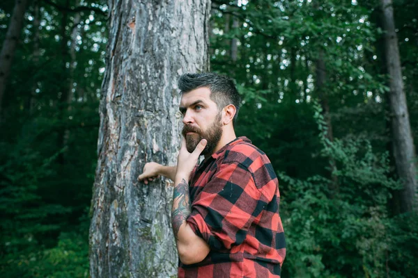 Un uomo barbuto nella foresta. Uomo barbuto con lunga barba sul paesaggio verde naturale . — Foto Stock