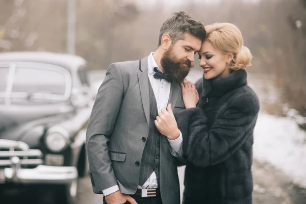 Para a aventura! Feliz casal amoroso é relaxante e desfrutar de viagem. Jovem mulher, homem e carro vintage no fundo natureza inverno. Natal feriados vezes — Fotografia de Stock