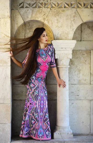 Belle femme en robe violette posant près des ruines romaines — Photo