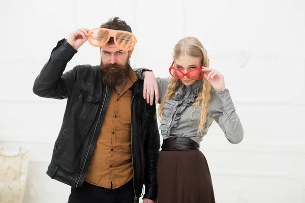 Couple élégant dans d'énormes lunettes orange posant en studio. Homme avec belle barbe et moustache étreignant blonde jolie fille. Tournage de mode — Photo