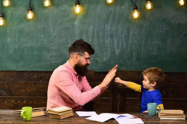 Bello insegnante e ragazzo carino che gioca in classe. Studentessa che porta a termine il compito. Piccolo campione saluto — Foto Stock