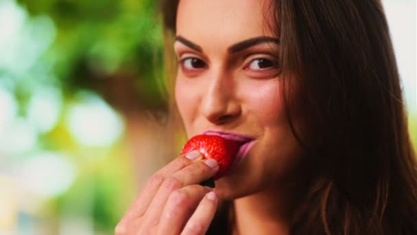 Vrouw met aardbei. Mooie vrouw eten van een aardbei. — Stockvideo