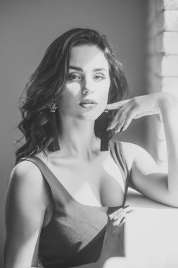 Gün ışığından yararlanma penceresinde standında uzun esmer saçlı kızla