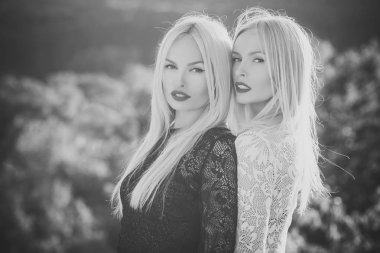 Kırmızı dudaklar ve uzun sarı saçları ile iki kadın