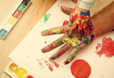 Renkli boyalar ve beyaz kağıt üzerinde çok renkli palet elinde