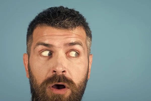 Homem com barba no rosto assustado no fundo azul — Fotografia de Stock