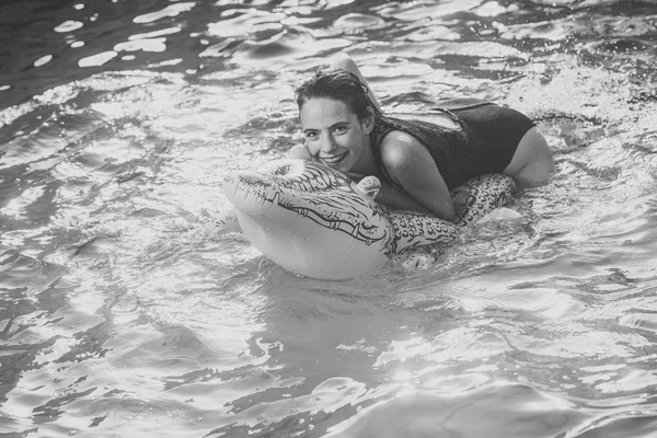 Mulher bonita na água com crocodilo inflável verde . — Fotografia de Stock