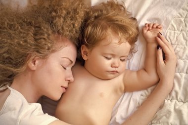 Anne bebeği kucaklıyor.