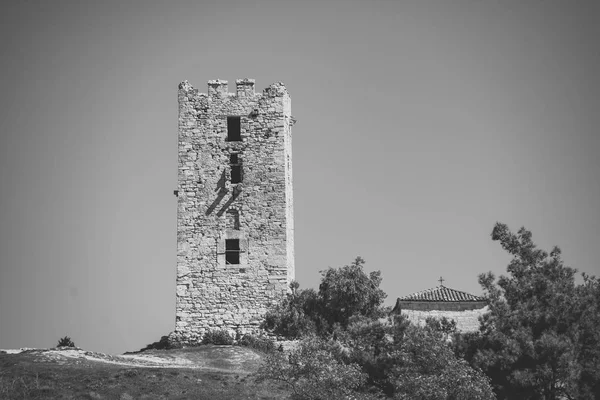 Ancient temple or tower on top of the hill surrounded by park or forest. Old building made out of bricks or stones, sky background. Cultural and architectural heritage concept