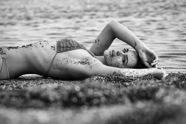 Menina bonita em maiô amarelo dormindo na praia do mar — Fotografia de Stock