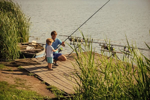 Батько вчить маленького сина рибалити у прісній воді — стокове фото