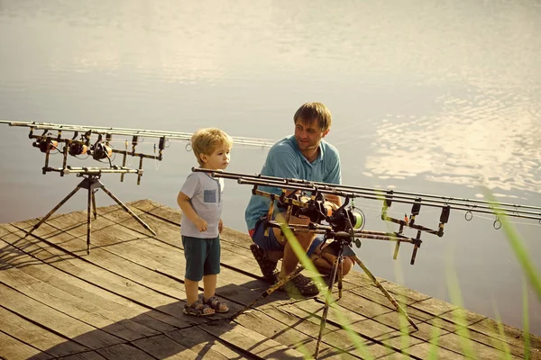 Мужчина и маленький мальчик проводят время на свежем воздухе и рыбалке — стоковое фото
