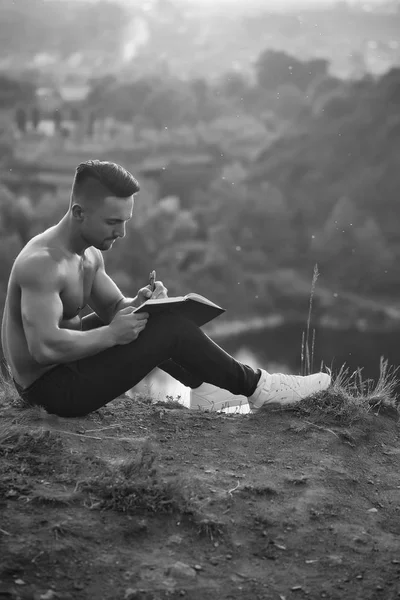 屋外の本で物思いにふける筋肉男 — ストック写真