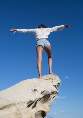 Dikiz ocean adlı bir güzel, esmer genç kız kaldırdı elleriyle. Özgürlük kavramı, açık gökyüzü arka plan ile plaj tatil