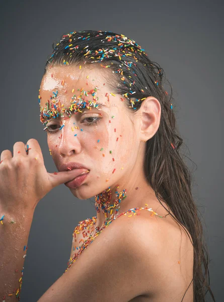 Mujer con caramelo espolvorear los labios sosteniendo el pulgar en la boca —  Fotos de Stock