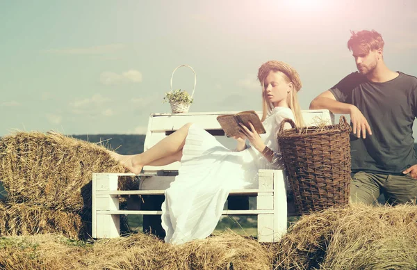 Famiglia godere della natura estiva. Donna sposa in abito da sposa rilassarsi sulla panchina. Una donna sensuale leggeva un libro per l'uomo. Coppia innamorata in vacanza. Fidanzata e fidanzato data all'aperto — Foto Stock