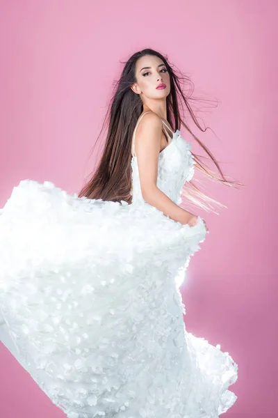 Tančící žena v bílých svatebních šatech. Tančící dívka na růžovém pozadí. — Stock fotografie
