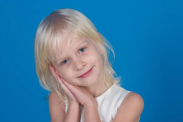 Kleines Mädchen mit blonden Haaren hält sich die Hände vors Gesicht. — Stockfoto
