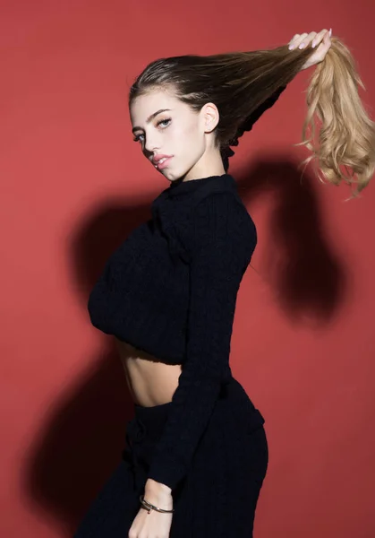 Moda e beleza. modelo de moda com cabelo longo e barriga ajuste sexy no fundo estúdio vermelho . — Fotografia de Stock