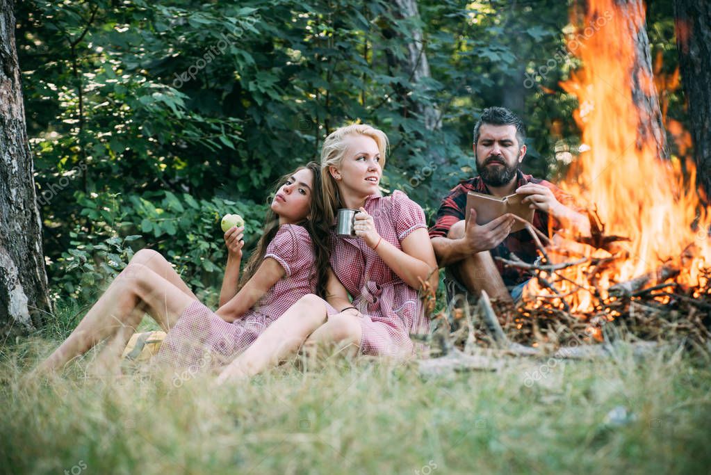 Group Of Friends Camping In Forest Guy Reading Book By Fire Beautiful Blond Girl Drinking Tea