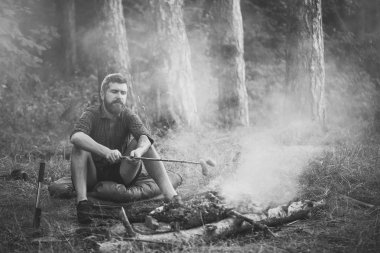 Adam Gezgin kızartma sosis ormanda kamp ateşi üzerinde sopa