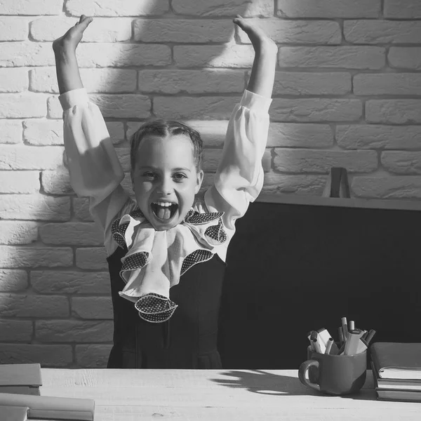 Meisje zit op Bureau met kleurrijke briefpapier en boeken — Stockfoto