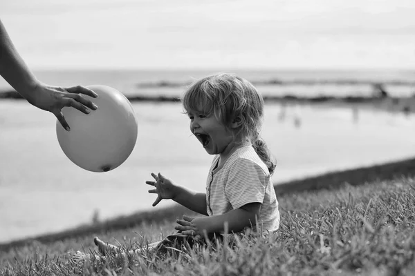 Feliz lindo bebé niño ríe la captura de globo amarillo — Foto de Stock