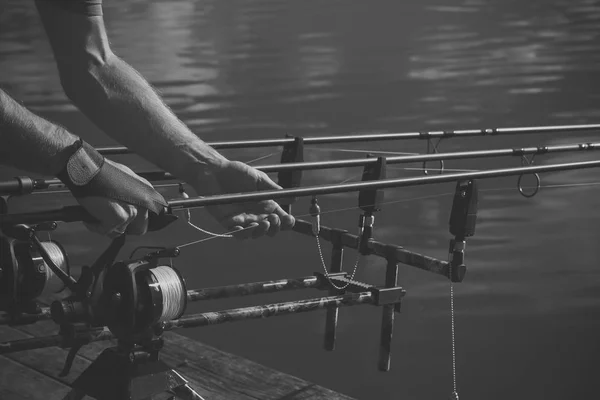 Canne, bobine, linee e mani maschili su fondo acqua, pesca — Foto Stock