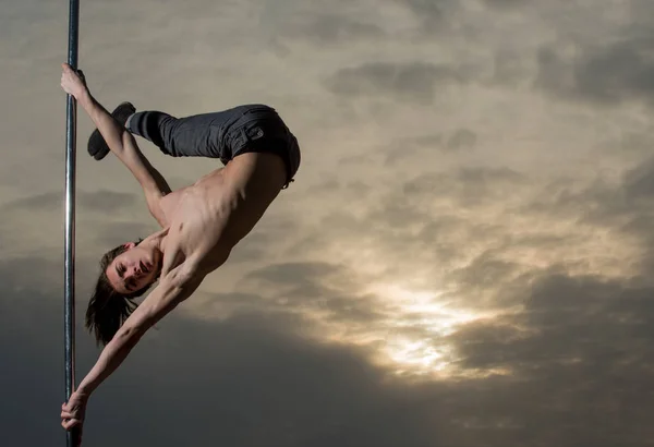 Jovem slim pole dance homem no céu fundo — Fotografia de Stock