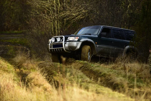 Course automobile en forêt d'automne. Concept de véhicule extrême, défi et 4x4. Course hors route sur fond de nature d'automne. SUV ou voiture hors route surmonte les obstacles — Photo