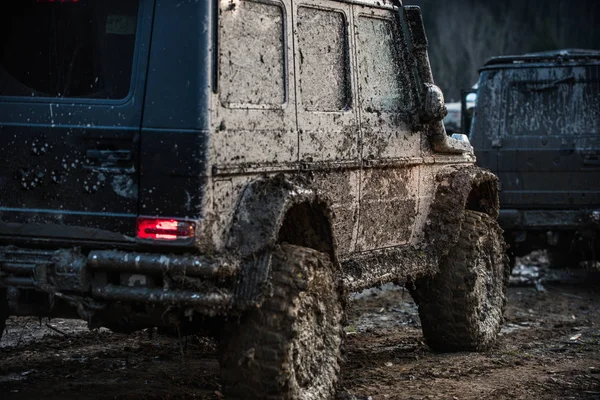 Dirty offroad cars on dark background, back view. — Stock Photo, Image