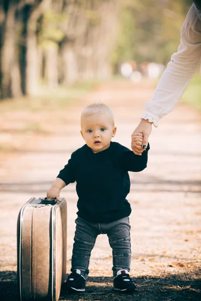 Πορτραίτου από αστείες μικρό αγόρι το περπάτημα στην εξοχή, στον δρόμο κρατώντας παλιά βαλίτσα. — Φωτογραφία Αρχείου